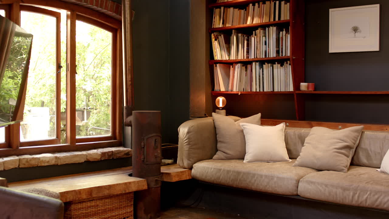 Cozy living room with bookshelf and sofa near window, warm and inviting, at home