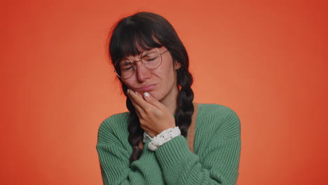 mujer tocando la mejilla que sufre de dolor de muelas, caries o gingivitis esperando una cita con el dentista