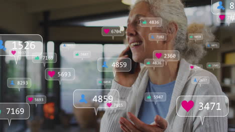 Animation-Von-Social-Media-Symbolen-Mit-Zahlen-über-Einer-älteren-Kaukasischen-Frau,-Die-Ein-Smartphone-Verwendet