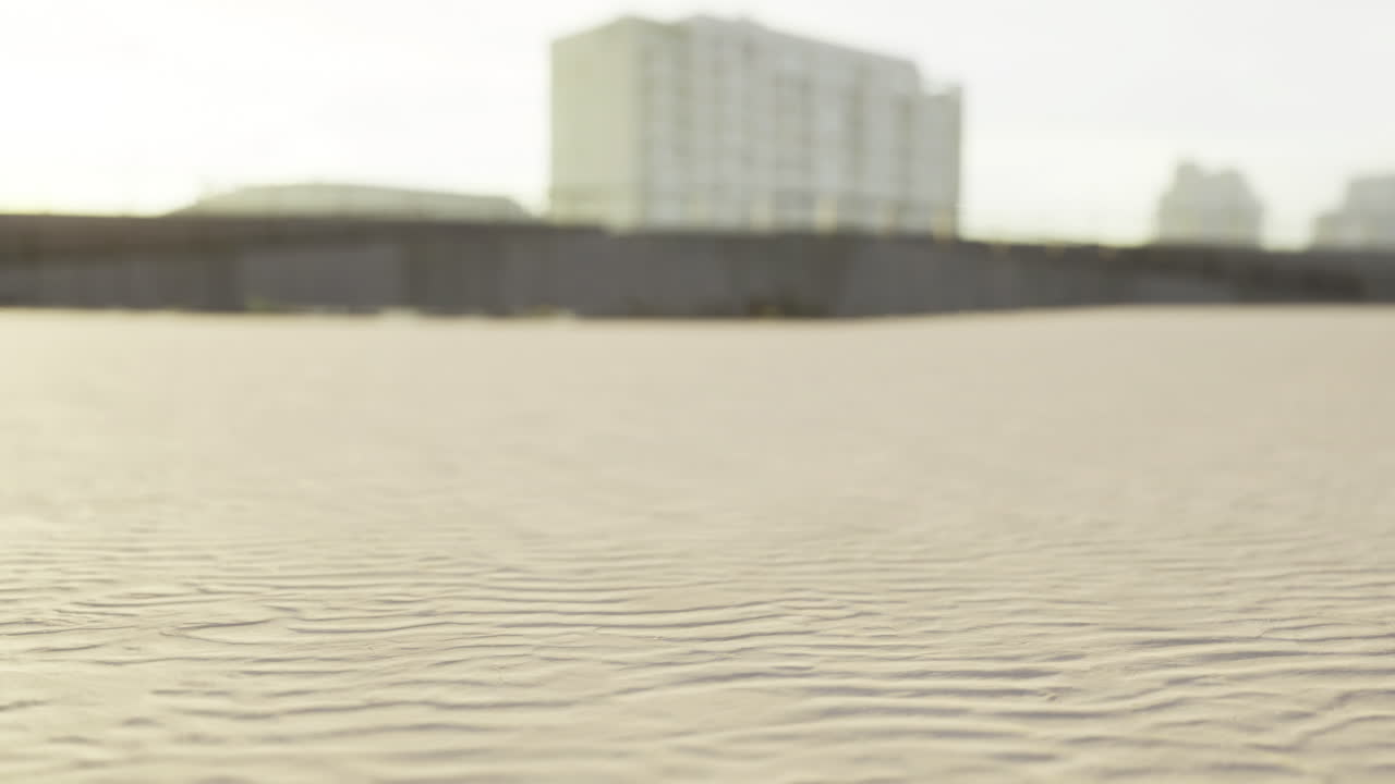 Warm golden sand stretches out beneath buildings overlooking the beach
