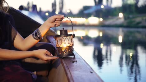 close-up of a night lamp in female hands. gondola floats along the river.