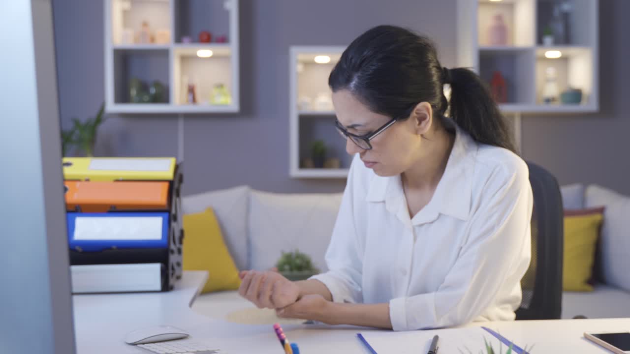 la mujer de negocios se duele la muñeca y se masajea la muñeca.