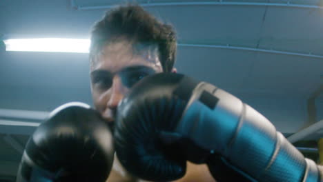 attractive young man doing shadow fight towards camera