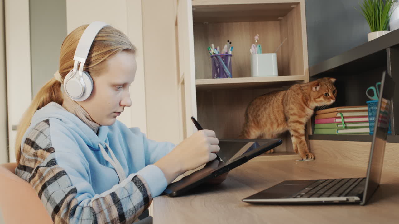 The girl draws, uses a digital graphics tablet. Inspiration and new technologies. Side view