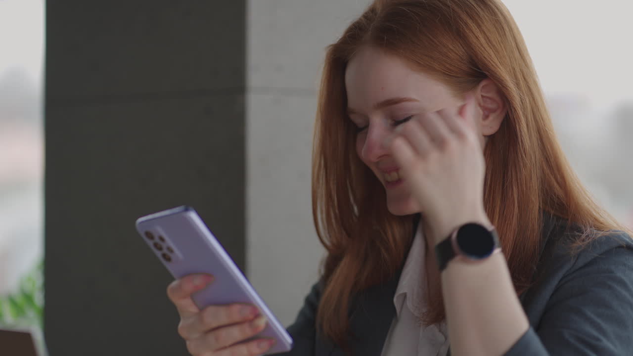 Young businesswoman use smart phone with laptop. Business woman in a modern office with a panoramic window sunny day laptop tablet use a mobile phone in a situation