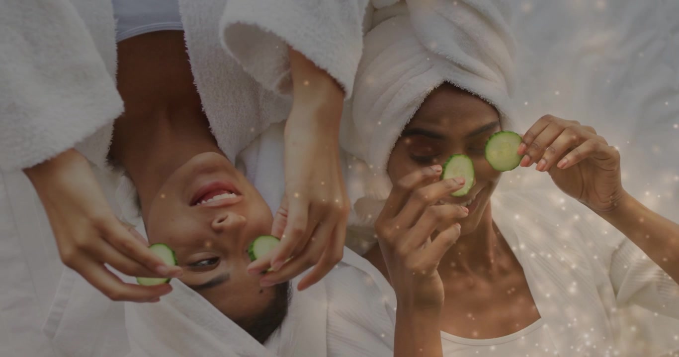 Donna a destra che alza le mani, sistemandosi il cetriolo, mentre quella a sinistra la imita su un lettino da spa, con un effetto calmante in sovrapposizione.