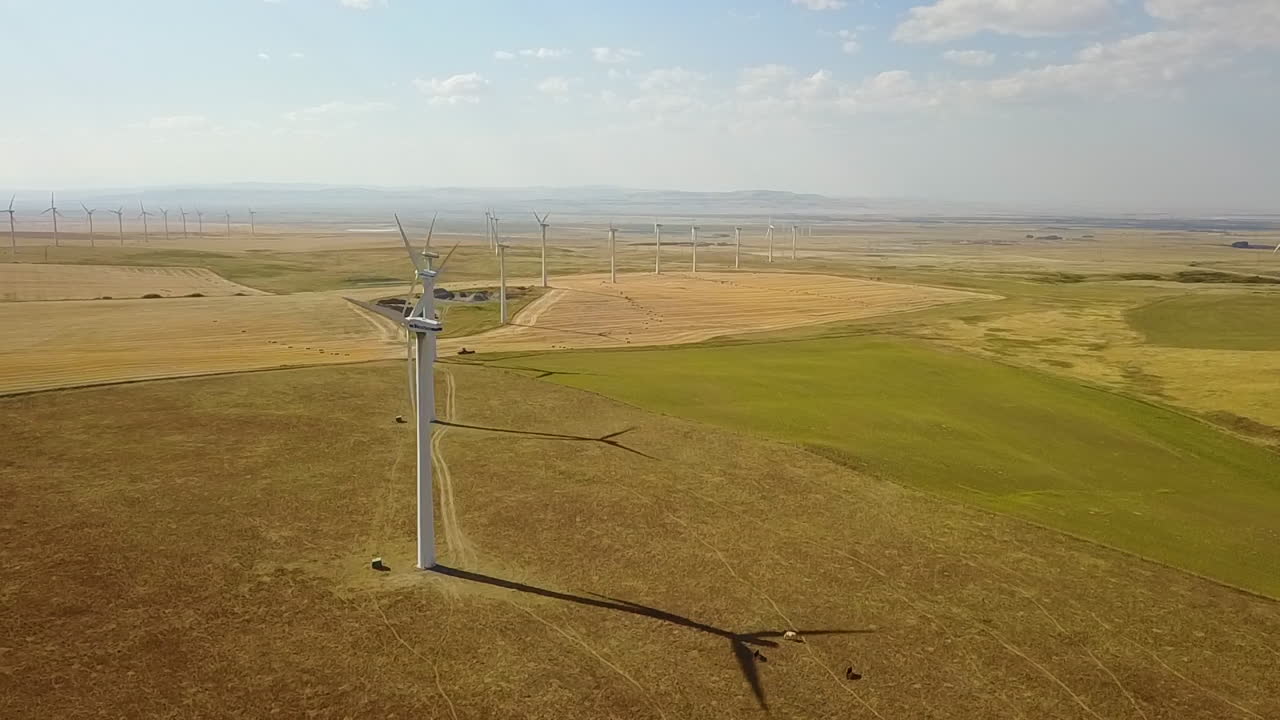 Aerial orbits wind turbines on prairie wind farm, renewable eco energy