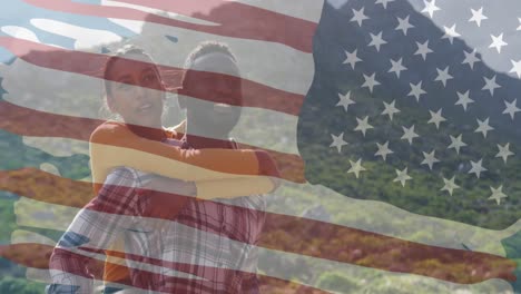 Animation-of-american-flag-over-smiling-diverse-couple-embracing-in-mountains