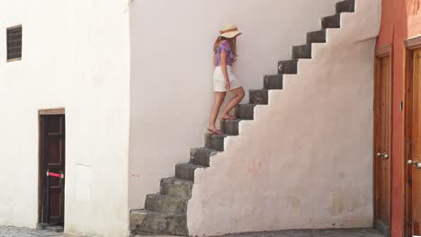 attractive woman walking up stairs in puerto de la cruz, side view