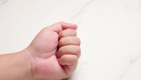 una persona estirando su mano izquierda abriéndola y cerrándola para liberar la tensión y aliviarla del dolor y la inflamación