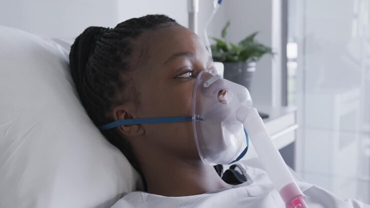 une patiente afro-américaine avec un masque à oxygène allongée dans un lit dans une chambre d'hôpital, au ralenti