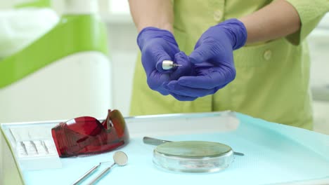 dentista insertando un taladro en la turbina dental. manos del médico con herramientas dentales