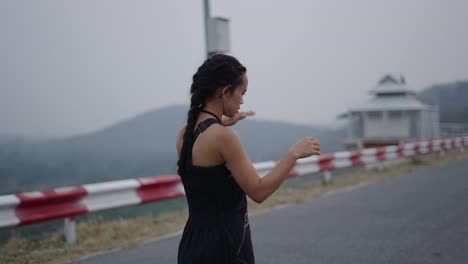 A woman on a road with outstretched arms