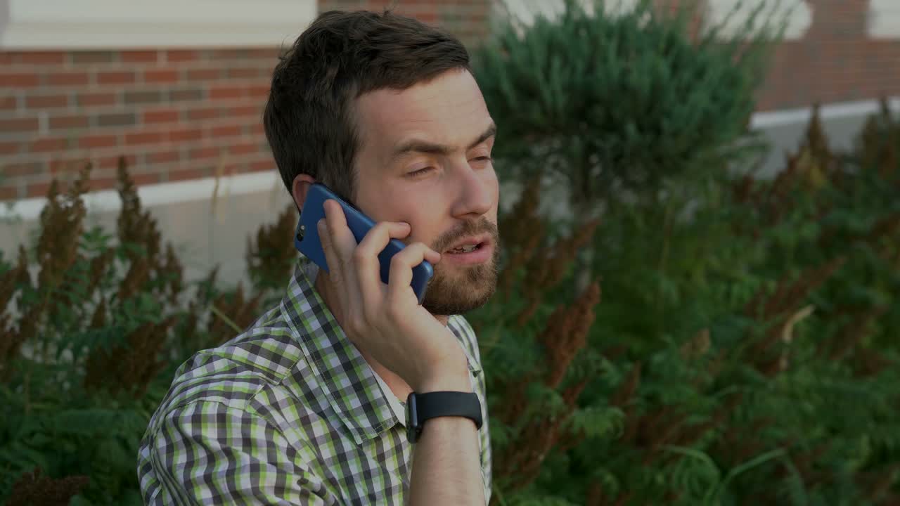 hombre hablando por teléfono móvil al aire libre
