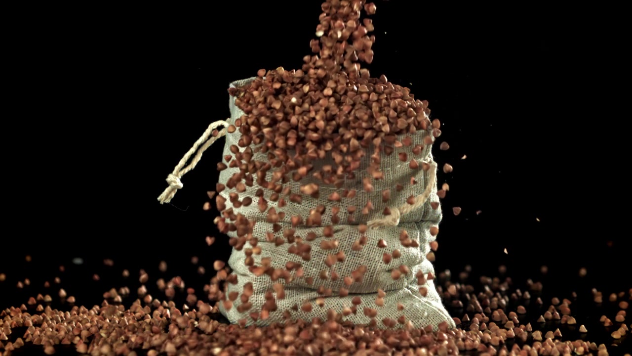 Grani di grano saraceno che si versano in un sacco di iuta