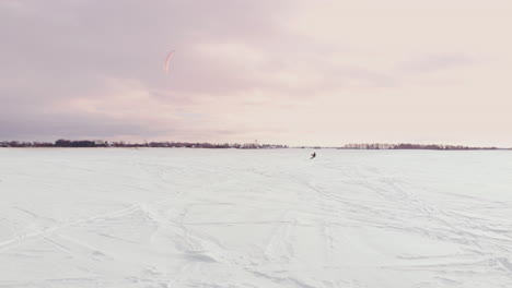 kitesurfing in the winter on snowboard or ski. skating on the ice in the wind. beautiful colored sails.