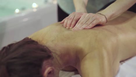 una mujer recibiendo un masaje de espalda en un spa.