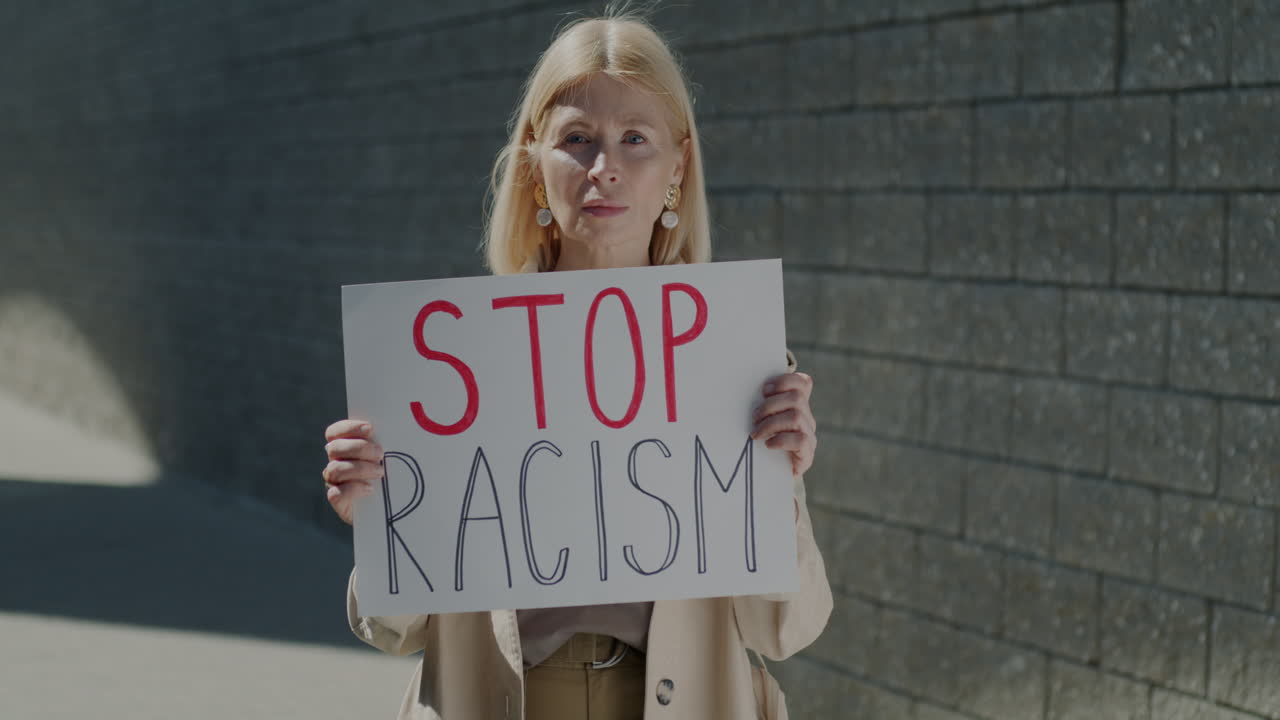 Woman Holding Protest Sign Saying 'Stop Racism'