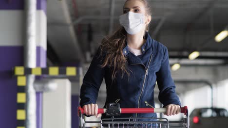 Video-Einer-Frau-Mit-Maske,-Die-Nach-Dem-Einkaufen-Auf-Dem-Parkplatz-Läuft