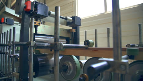 equipment with multiple rollers of diverse width. shafts rotate and move the timber bar further. door manufacturing company.