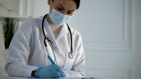 Doctora-Llenando-Documentos-Hospitalarios-De-Diagnóstico-Y-Prescripción-Para-El-Tratamiento-De-Un-Paciente
