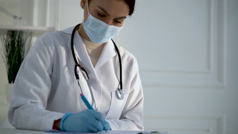 female doctor filling in hospital papers of diagnosis and prescription for the treatment of a patient