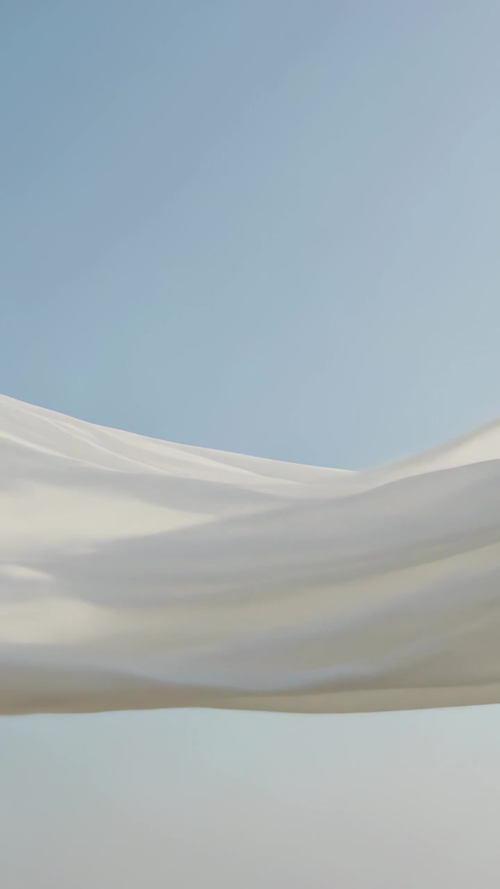 Vertical video: Billowing sheer white fabric strips drifting across clear sky, pushed by breeze