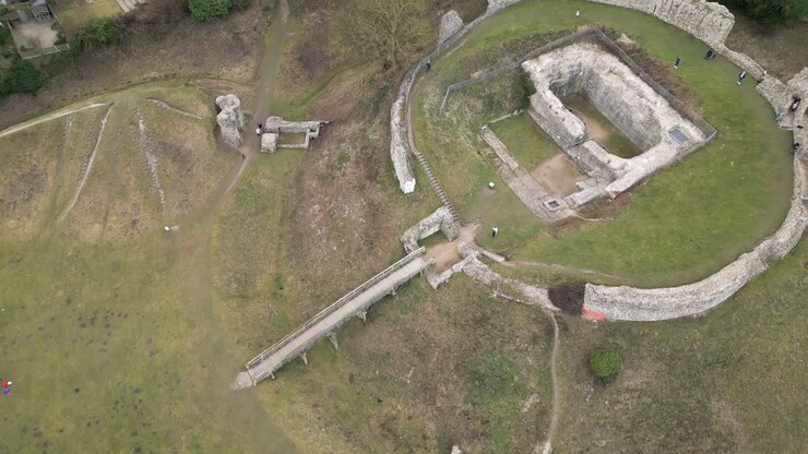 Vista aerea con drone in ascesa a spirale delle rovine di Castle Acre e Bailey Gate, Norwich, Regno Unito