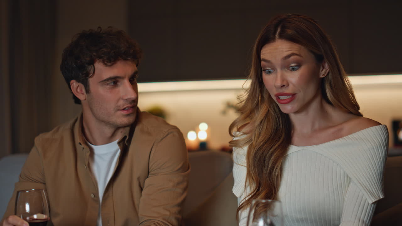 Romantic pair relaxing evening date holding wine glasses closeup. Couple talking