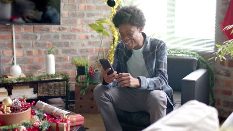 happy african american man having video call using smartphone at home, slow motion