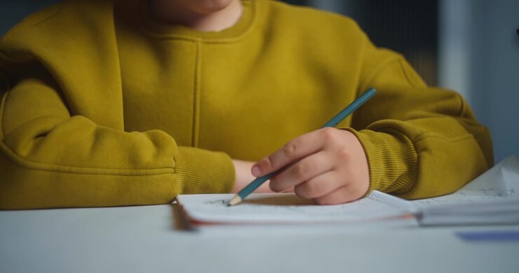 Giovane ragazzo concentrato con le cuffie che fa i compiti