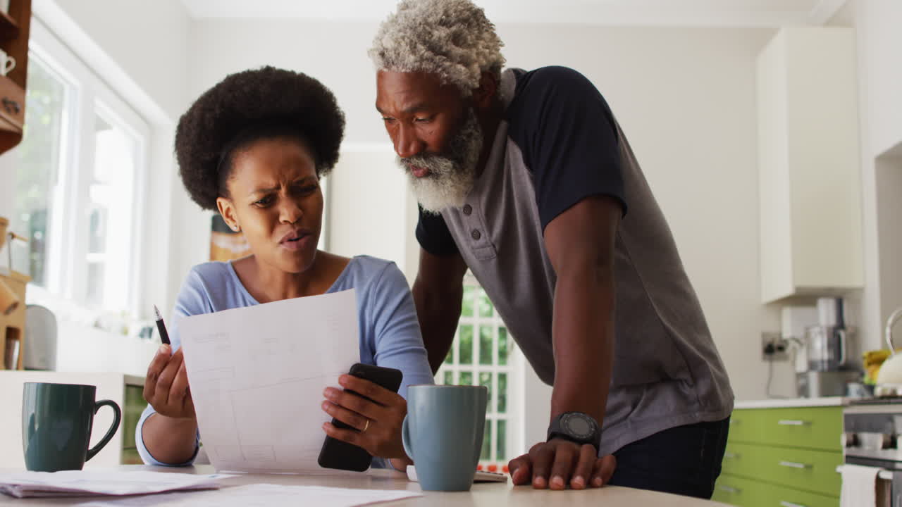 Concerned african american couple sitting paying bills