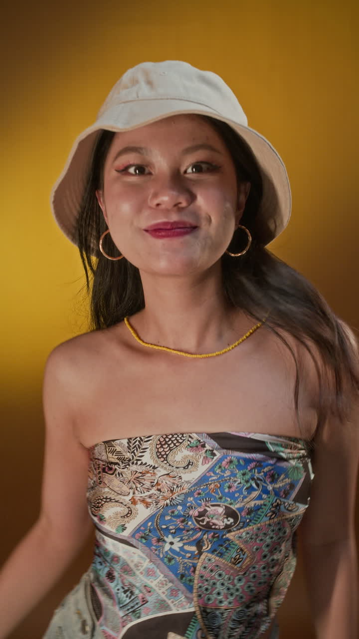 Female Zoomer in Hat Having Fun and Dancing in Studio with Yellow Light