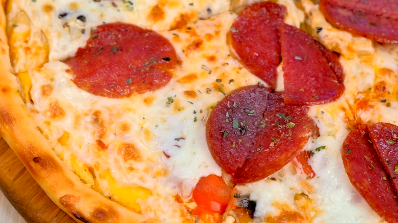 테이블 위의 나무판에 살라미 피자.