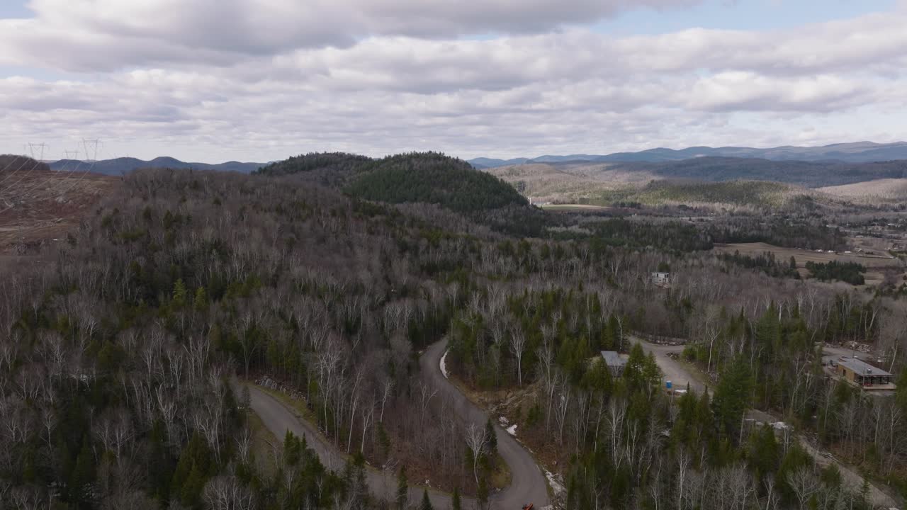 camino sinuoso en árboles densos reveló montañas en mont-tremblant, quebec, canadá