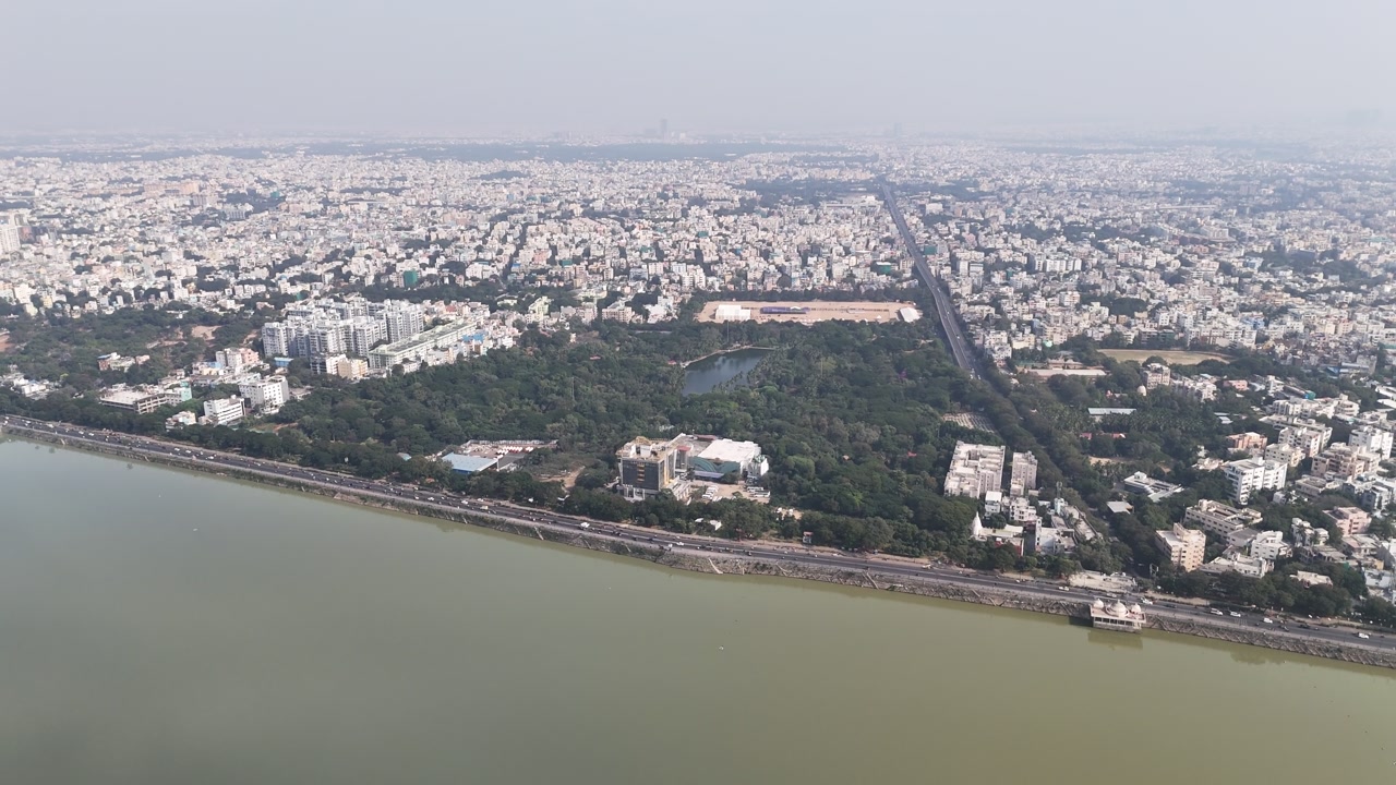 Telangana-based South Indian city's residential and commercial areas are visible in aerial footage. appears from above. urban centre for commerce and one of Hyderabad's footages of Hussain Sagar Lake