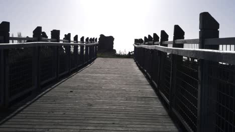 walking across empty wooden bridge wide zoom shot
