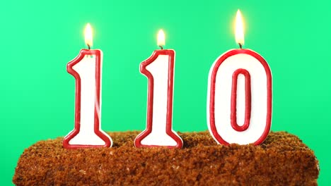 cake with the number 110 lighted candle. chroma key. green screen. isolated