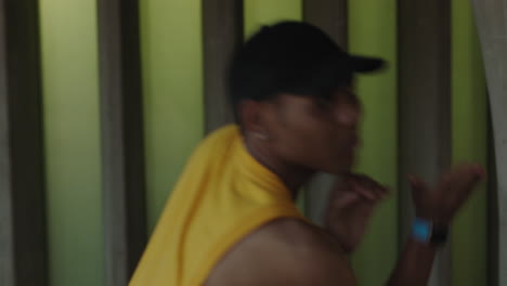 hombre bailarín joven bailarín de calle feliz realizando varios movimientos de baile de estilo libre adecuado hombre de raza mixta practicando con chaleco amarillo de cerca