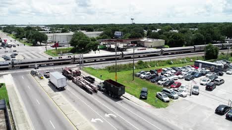 Un-Tren-Amtrak-Cruza-Una-Concurrida-Intersección-En-Una-Zona-Comercial-De-Orlando,-Florida