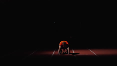 runner at the starting block at night