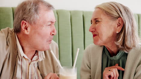 una pareja de mayores compartiendo una copa en un café.