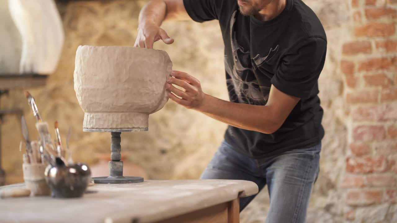 el alfarero está decorando una olla de cerámica. artista inspirado diseñando un jarrón en el taller. alfarero profesional haciendo productos de cerámica, video de demostración