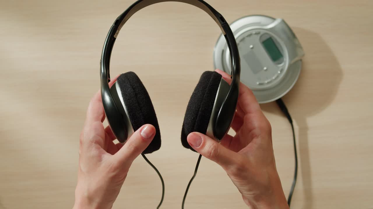 휴대용 cd 플레이어 와 헤드폰 을 들고 있는 손