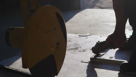 Grinder-Polishing-Metal-Frame-With-Cut-off-Machine-In-Foreground