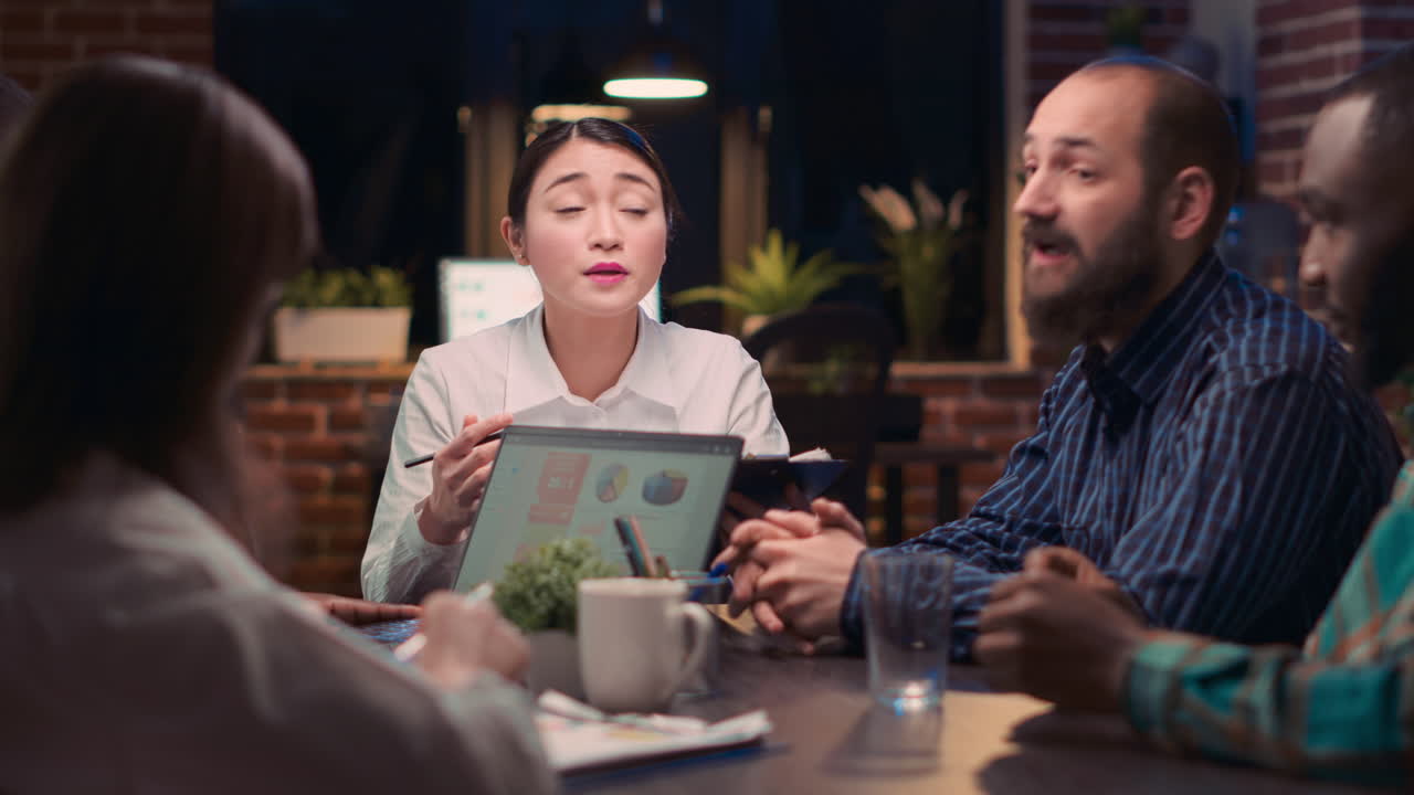Asian woman speaking at table in business meeting