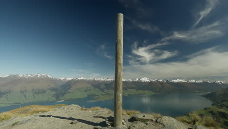 Wooden-Summit-Pole-on-Isthmus-Peak-in-New-Zealand-with-amazing-view-of-landscape