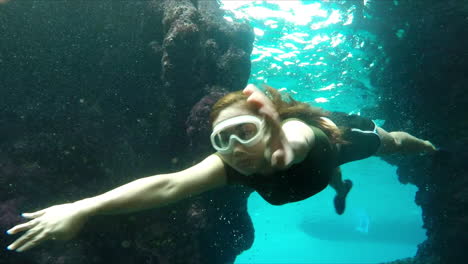 young girl swimming under clear blue water exploring deep mysterious sea