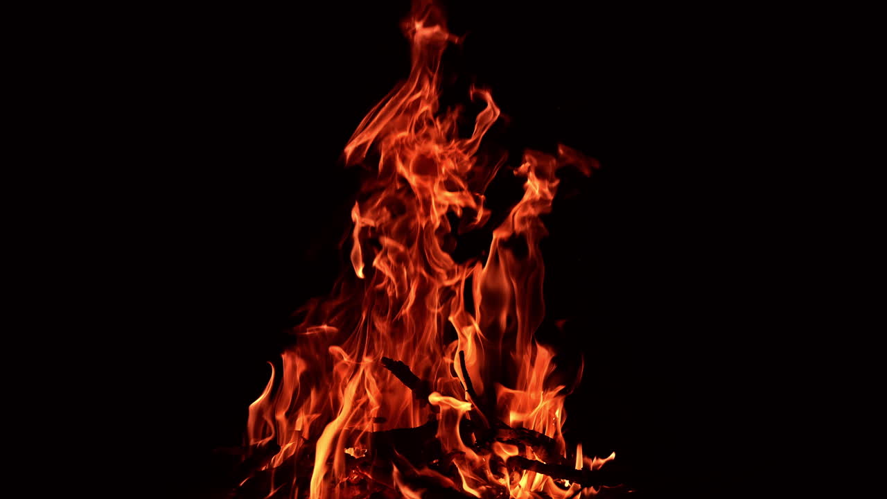 Dry wooden sticks burning well in a big campfire. Large bonfire on the ground burn at night.