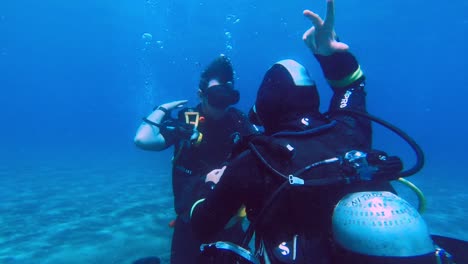 diving instructor teaching underwater a young man breathing diving techniques in order to obtain his diving certificate